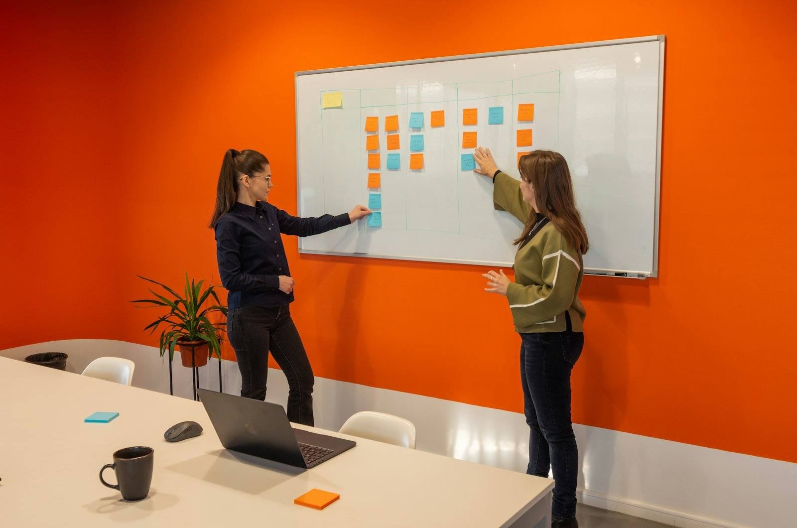 Two colleagues planning at a whiteboard